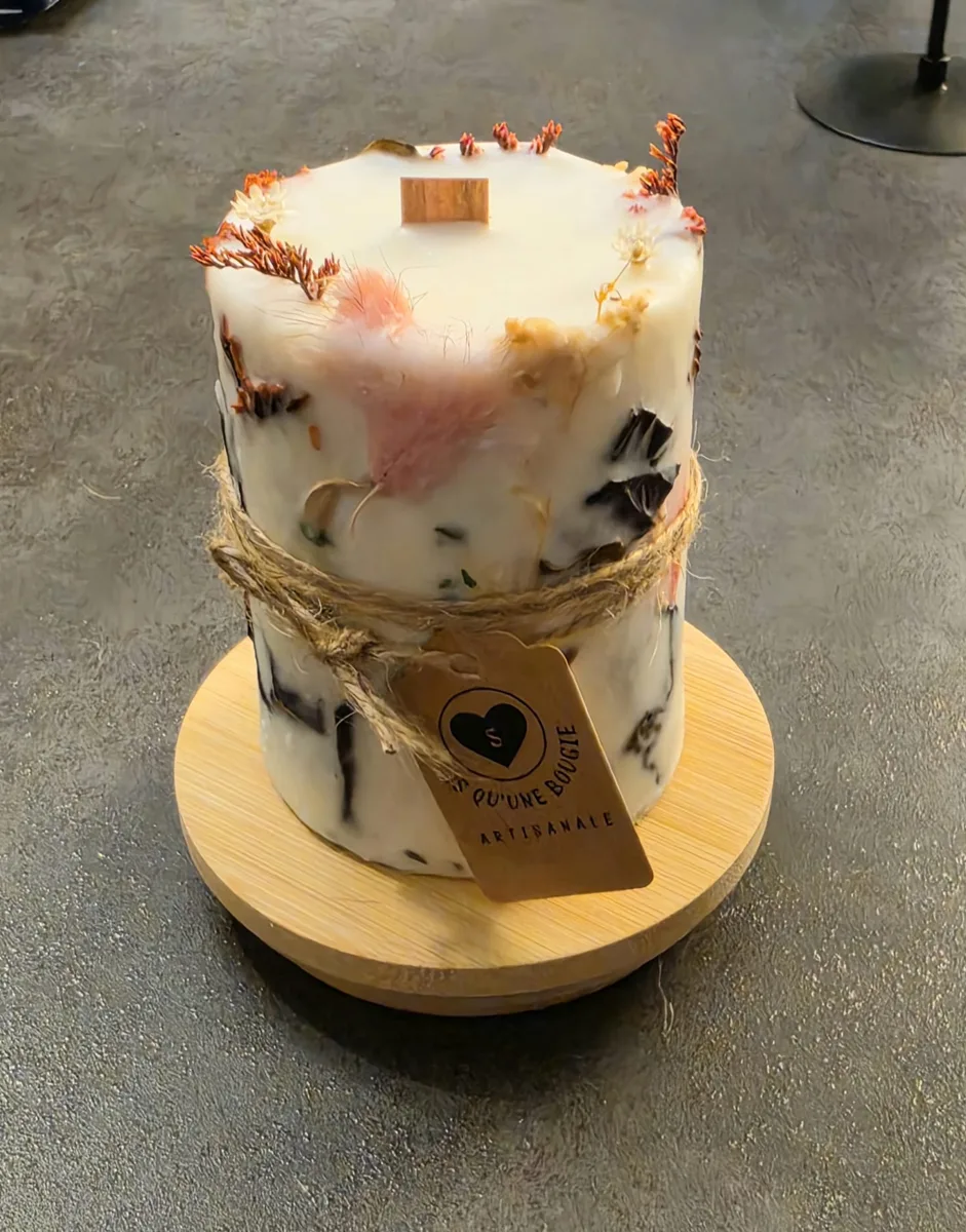 Bougie pilier ornée de fleurs séchées sur socle en bambou