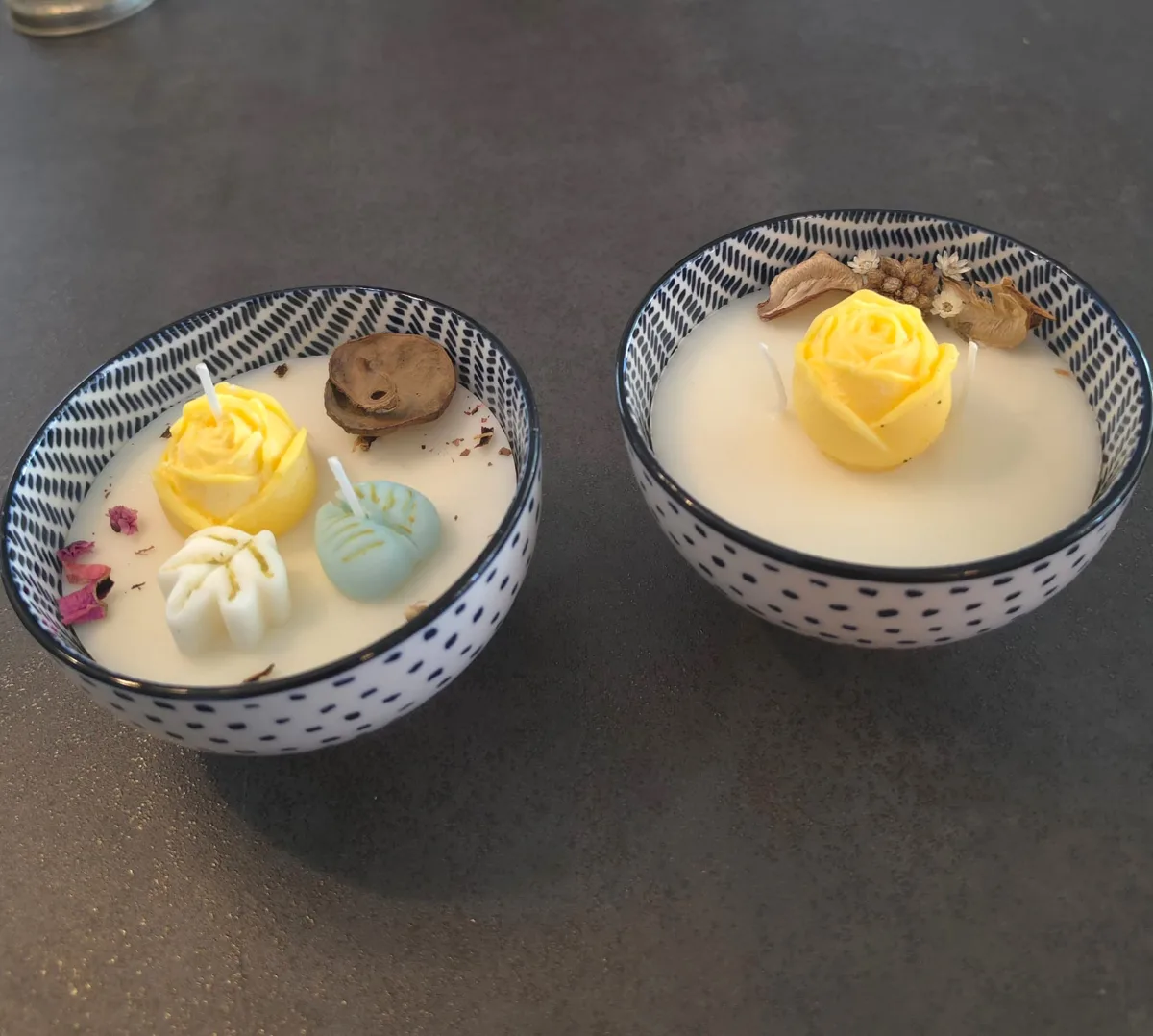 Deux bougies dans des bols en céramique avec roses jaunes en cire