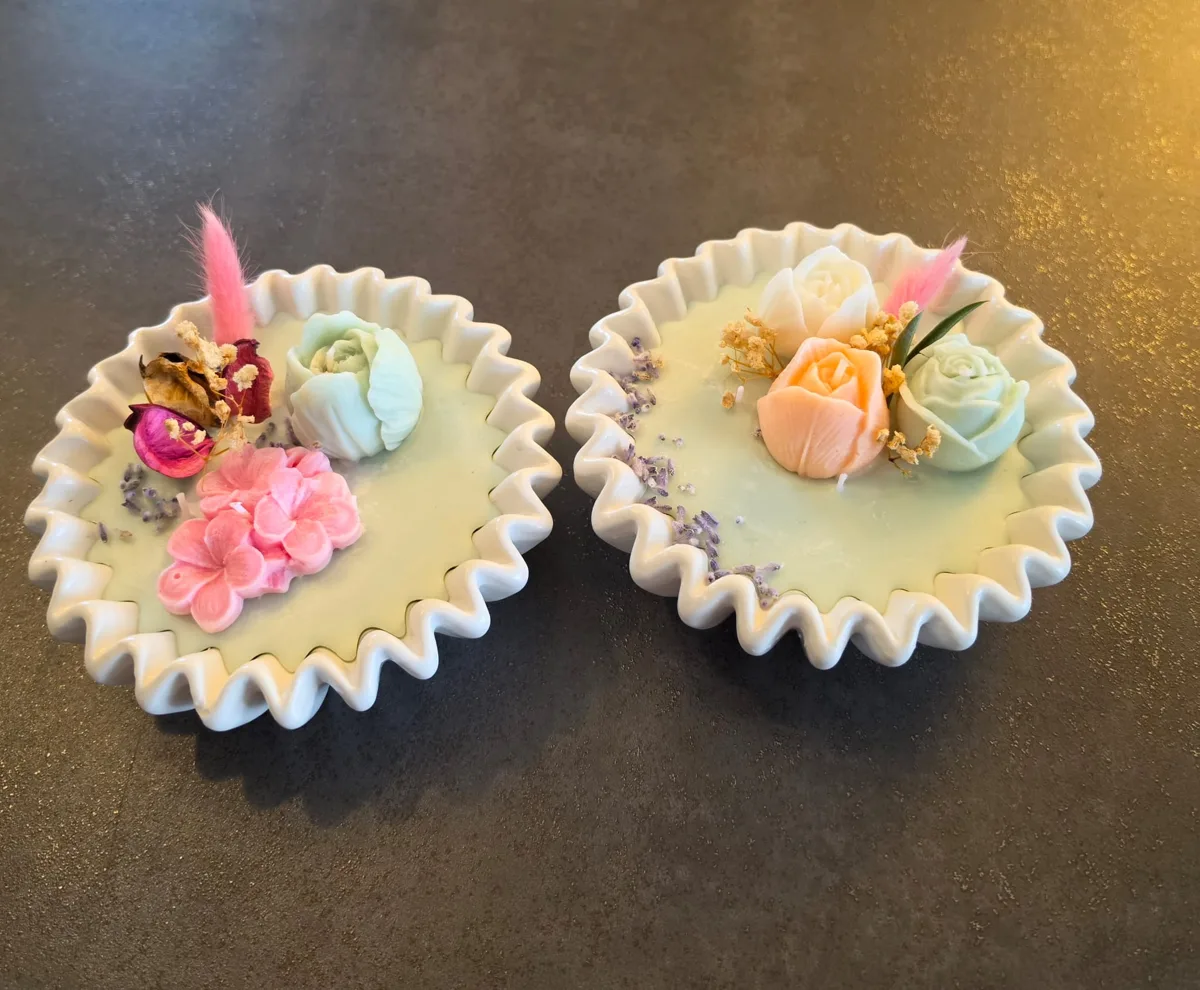 Deux bougies en coupelles ornées de fleurs en cire