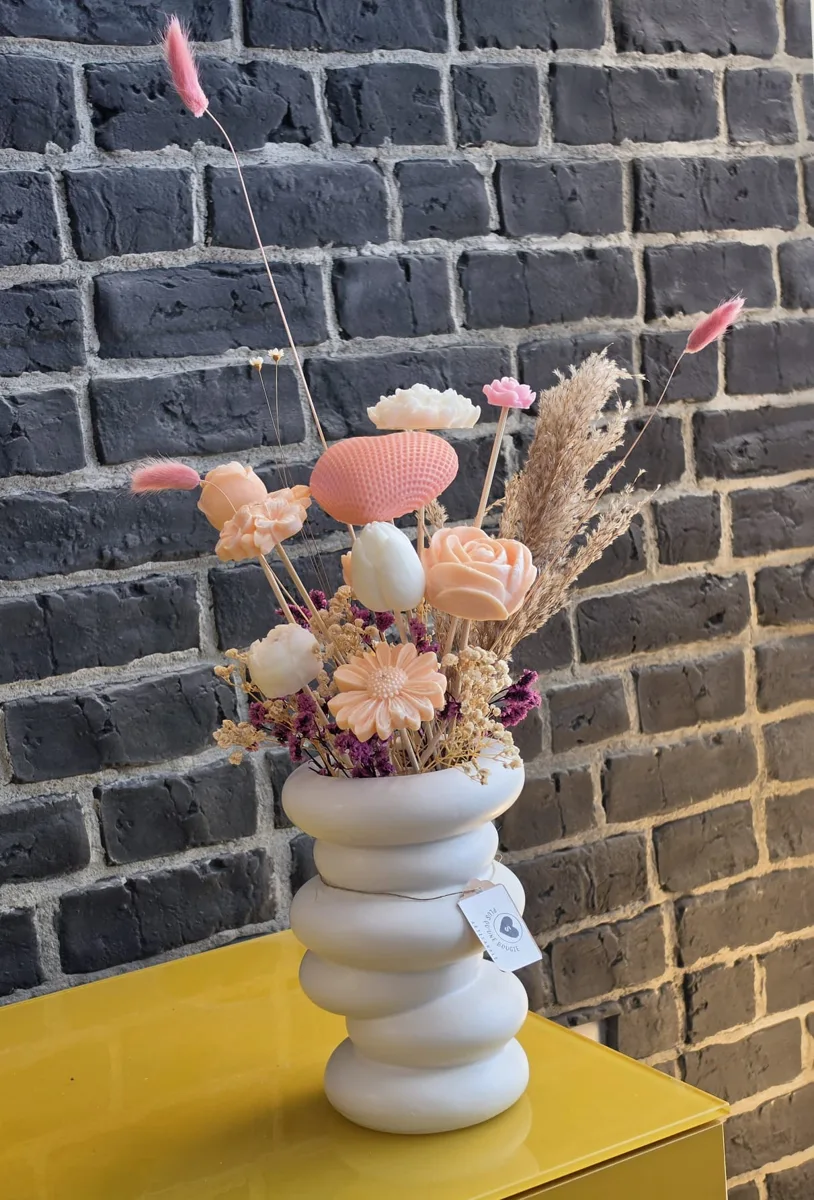 Bouquet de fleurs en cire dans un vase blanc en spirale