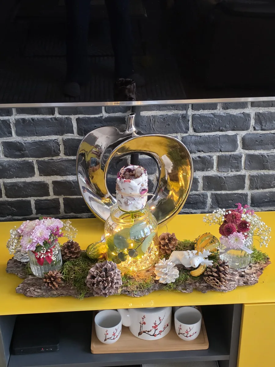 Composition de bougies et de fleurs sur un meuble de salon