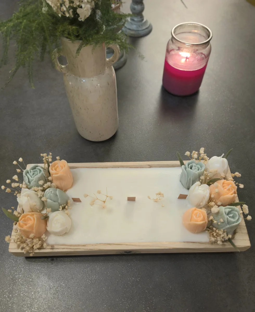 Plateau en bois avec bougie et roses en cire